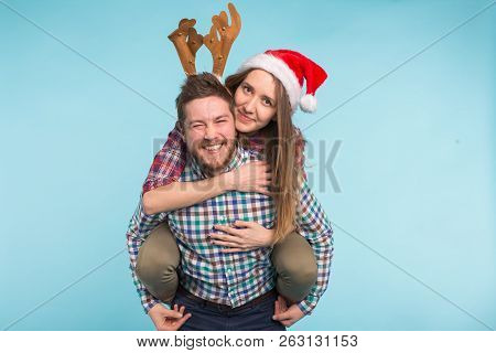 Christmas, People Concept - Romantic Young Couple Enjoying Christmas Time. Girl Jumped On Mans Back 