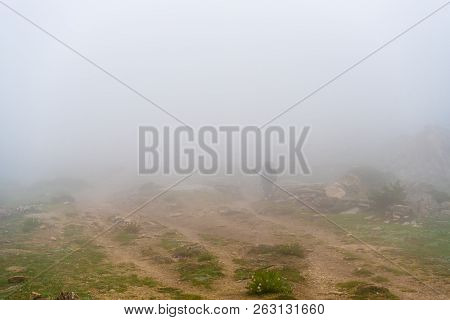 Unrecognizable Backpacker On Foggy Trekking Path In Annapurna Conservation Area, Nepal