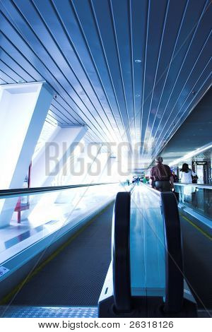 Spostare le persone sulla scala mobile nel ponte di vetro