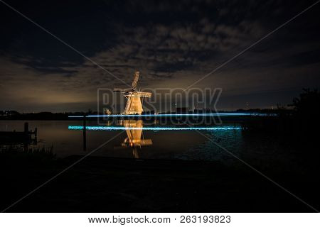 These Beautiful Windmills In Kinderdijk Are Illuminated With White Light At The Blue Hour