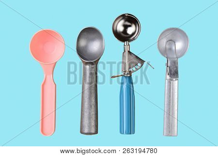 Ice Cream Scoops on a light aqua background.. High angle shot of four different scoopers.