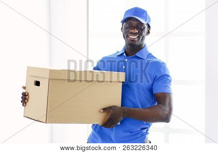 Portrait Of An Handsome Happy Deliverer With Box