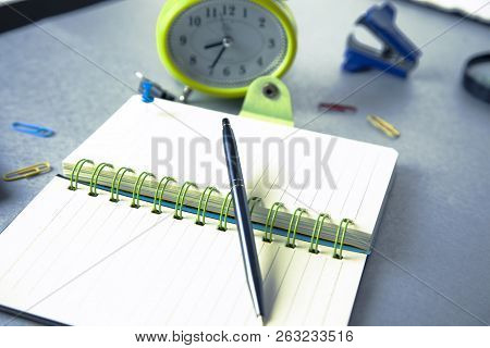 Clock With Stationery On Dark  Table Background