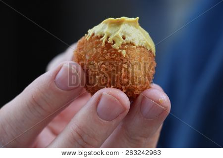 Dutch Snack:  Man Eating A Bitterbal With Mustard. Warm Stuffed Fried Meatballs, Often Served With A