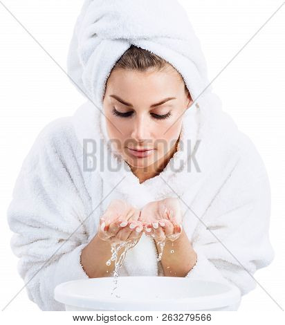 Young Woman In Bathrobe Washing Face With Clean Water. Front View. Isolated On White.