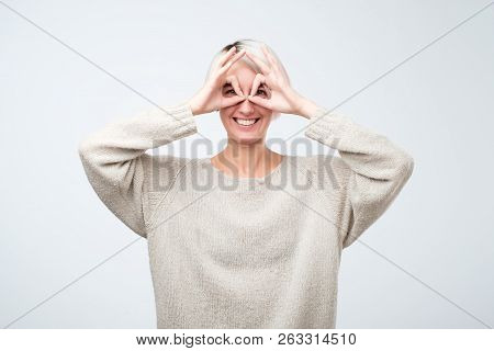 Pretty Girl With Surprised Face Holding Fingers Near Eyes Like Glasses: Mask Like Super Hero Or Owl