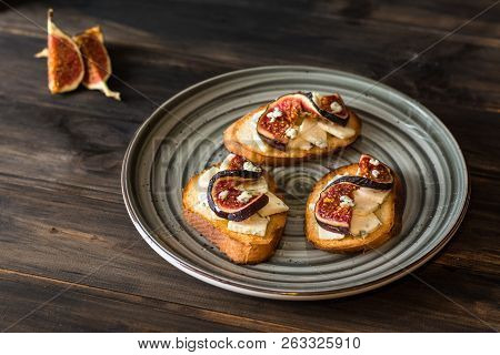 Sandwiches With Ricotta, Fresh Figs, Walnuts And Honey On Rustic Wooden Board Over Black Backdrop, T