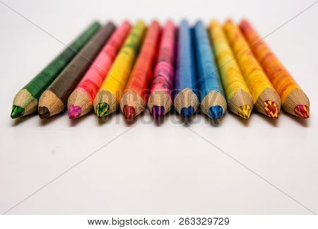 Set Of Colored Pencils Lying On The Notebook. White Background. Isolate. Christmas Colors