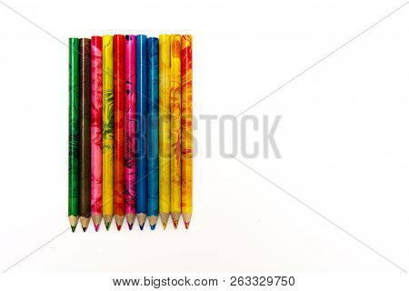 Set Of Colored Pencils Lying On The Notebook. White Background. Isolate. Christmas Colors