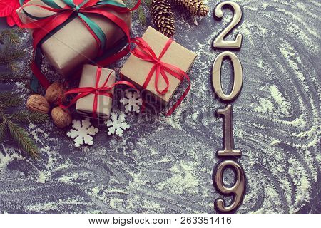 Festive Christmas Composition With Gifts, Boxes, Cones, Walnuts, Red Poinsettia Flowers On A Wooden 