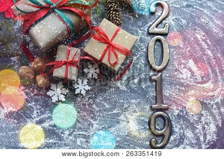 Festive Christmas Composition With Gifts, Boxes, Cones, Walnuts, Red Poinsettia Flowers On A Wooden 