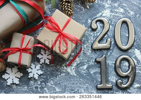 Festive Christmas Composition With Gifts, Boxes, Cones, Walnuts, Red Poinsettia Flowers On A Wooden 