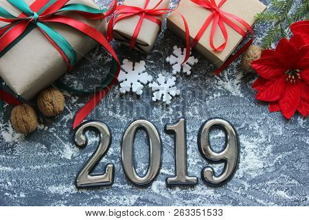 Festive Christmas Composition With Gifts, Boxes, Cones, Walnuts, Red Poinsettia Flowers On A Wooden 