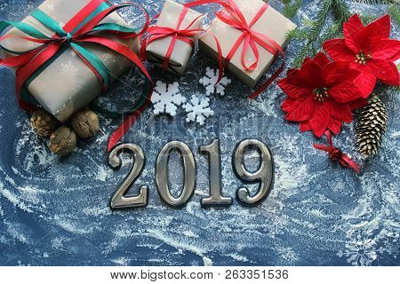 Festive Christmas Composition With Gifts, Boxes, Cones, Walnuts, Red Poinsettia Flowers On A Wooden 