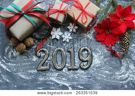 Festive Christmas Composition With Gifts, Boxes, Cones, Walnuts, Red Poinsettia Flowers On A Wooden 