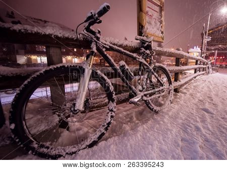 end of biking season.parked bicycle covered by snow from a heavy snowstorm.Winter cycling