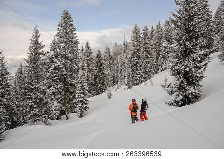 Two Snowboarders Standing In The Mountain And Looking Into A Distance In The Popular Tourist Resort 