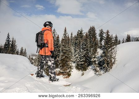 Man Standing On The Snowboard In The Mountain And Looking Into A Distance In The Popular Tourist Res