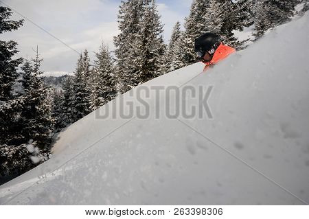 Man Running Down The Mountain Hill On The Snowboard On The Background Of Sky And Trees On The Snow C