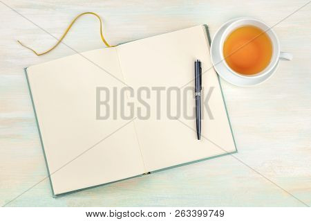 A Photo Of An Open Journal With A Pen And A Cup Of Tea, Shot From Above, On A Light Background With 