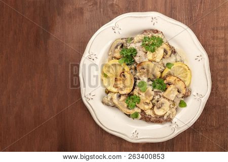 A Photo Of Scallopine Di Vitello, Veal Scallopini, With A Mushroom Sauce, Lemons, And Parsley, Shot 