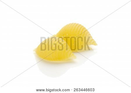 Group Of Two Whole Raw Yellow Pasta Conchiglie Variety Like Seashells Isolated On White Background