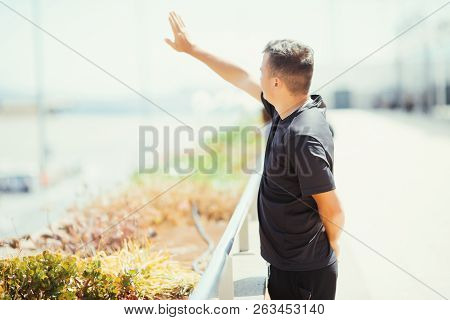 Saying Goodbye At The Airport. Young Man Traveler Waves His Hand To Departure Plane.