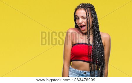 Young braided hair african american with pigmentation blemish birth mark over isolated background winking looking at the camera with sexy expression, cheerful and happy face.