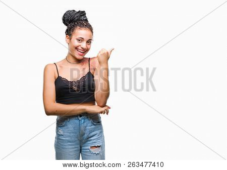 Young braided hair african american with pigmentation blemish birth mark over isolated background smiling with happy face looking and pointing to the side with thumb up.