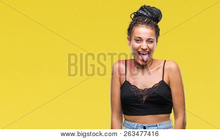 Young braided hair african american with pigmentation blemish birth mark over isolated background sticking tongue out happy with funny expression. Emotion concept.