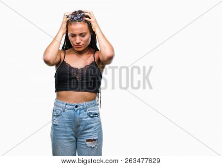 Young braided hair african american with pigmentation blemish birth mark over isolated background suffering from headache desperate and stressed because pain and migraine. Hands on head.