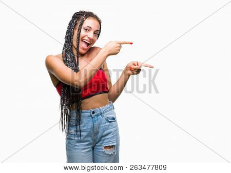 Young braided hair african american with pigmentation blemish birth mark over isolated background smiling and looking at the camera pointing with two hands and fingers to the side.