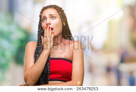 Young braided hair african american with pigmentation blemish birth mark over isolated background bored yawning tired covering mouth with hand. Restless and sleepiness.