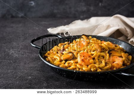 Traditional Spanish Fideua. Noodle Paella On Black Stone. Copyspace