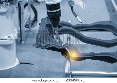 The Welding Robot Machine For Welding Automotive Part In The Light Blue Scene.industrial 4.0 Concept