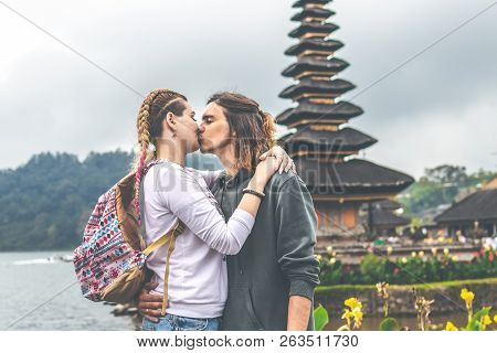 Young Romantic Couple Of Trourists On The Ulan Danu Temple Background. Bali Island.
