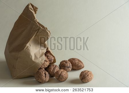 Walnuts Overspill From A Damaged Paper Bag On A Green Kitchen Table