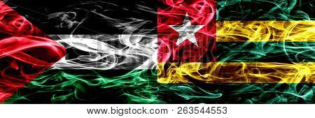 Palestine Vs Togo, Togolese Smoke Flags Placed Side By Side. Thick Colored Silky Smoke Flags Of Pale