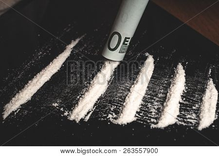 Drug Addict Snorting Lines Of Cocaine Or Methamphetamine Powder Narcotic With Rolled Banknote, Close