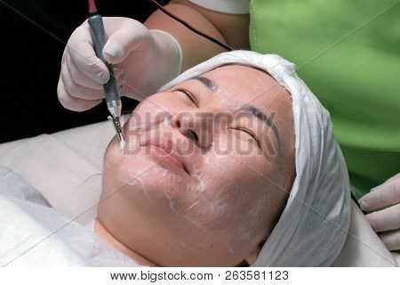 Hardware Cosmetology. A Muslim Woman With Her Eyes Closed Smiles During A Therapeutic Disincrustatio
