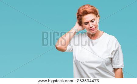 Atrractive senior caucasian redhead woman over isolated background confuse and wonder about question. Uncertain with doubt, thinking with hand on head. Pensive concept.