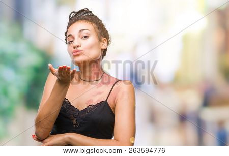 Young braided hair african american with pigmentation blemish birth mark over isolated background looking at the camera blowing a kiss with hand on air being lovely and sexy. Love expression.