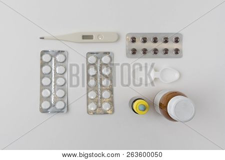 Top View Over A Pattern With Pills, Thermometer, Different Bottles With Syrips And Drops, Measuring 