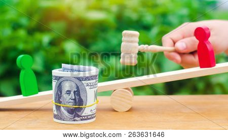 Wooden Figures Of People On Scales And Dollars Between Them. A Dispute Between Two Businessmen. Tria