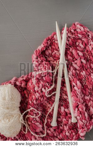 Knitting Yarns And Knitting Needles On Grey Background.