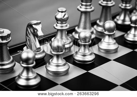 Chess Pieces On A Black And White Chess Board.