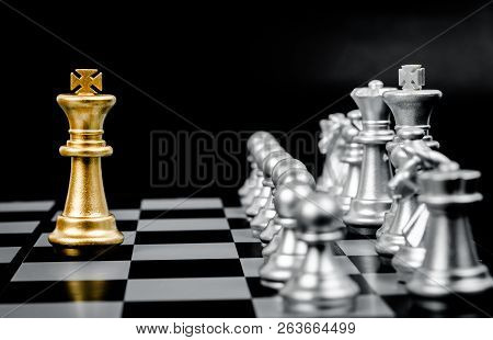 Gold Chess Pieces On A Black And White Chess Board.
