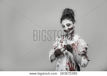 Scary Damaged Girl In Nurce Halloween Costume Looking Like Zombie With Pills On Grey Background
