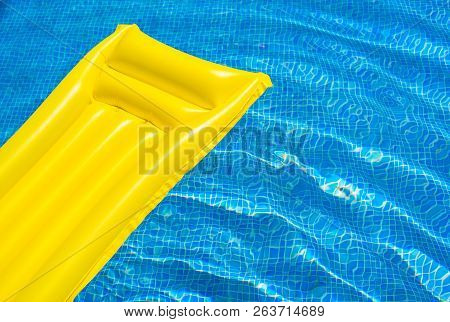 Yellow Inflatable Pool Raft Air Bed In Wavy Swimming Pool Water