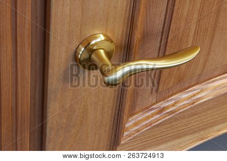 Metal Door Handle In A Wooden Door, Closeup. Door Handle In The Interior.
